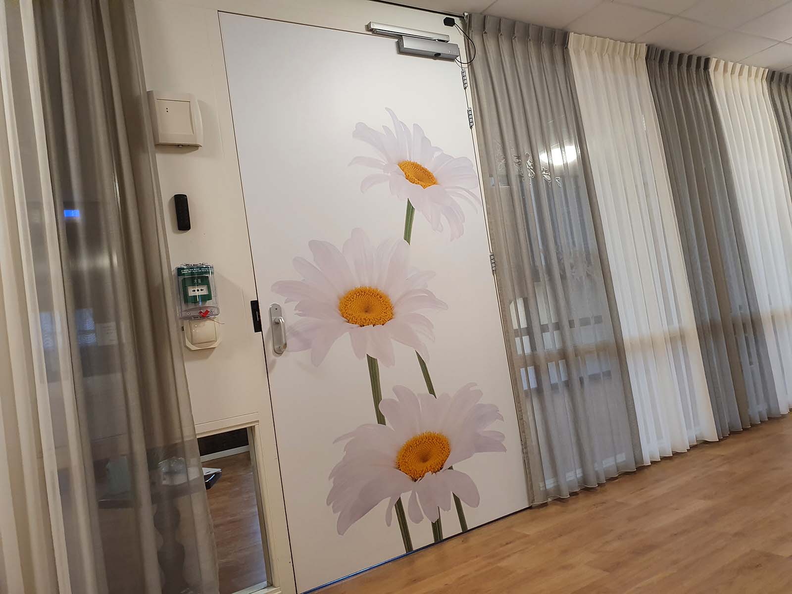 Mooie deursticker met schitterende foto van een witte bloem in verzorgingshuis